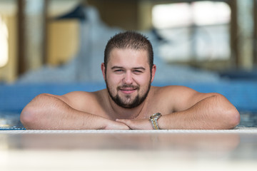 Overweight Man Relaxing In The Swimming Pool