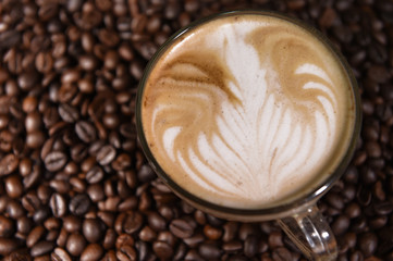 Latte art, coffee in coffee beans background.