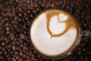 Latte art, coffee in coffee beans background.