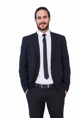 Smiling businessman in suit standing with hands in pockets