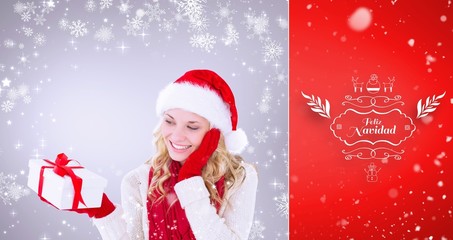 Composite image of happy festive blonde with gift
