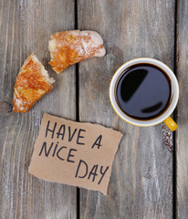 Composition of coffee, fresh croissant and paper card