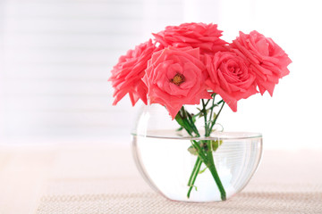 Beautiful flowers in vase with light from window
