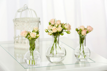 Obraz na płótnie Canvas Beautiful bouquet of flowers in vases on window background