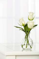 Beautiful bouquet of flowers in vase on window background