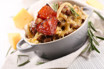 Pasta baked with vegetables and cheese in ceramic pot