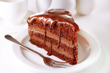 Delicious chocolate cake on plate on table on light background