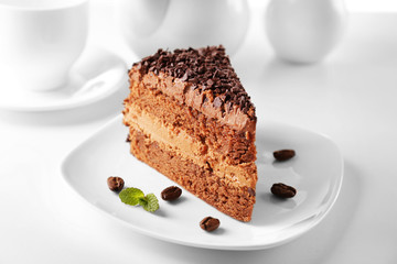 Delicious chocolate cake on plate on table on light background