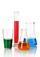 Test-tube and flasks with colorful fluid on light background