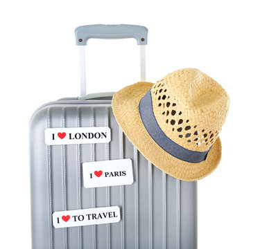 Travel suitcase and hat isolated on white