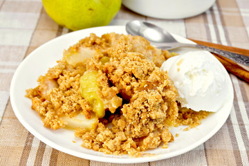 Crumble with pears in plate on tablecloth