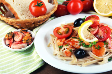 Tasty pasta with shrimps, mussels, black olives and tomato