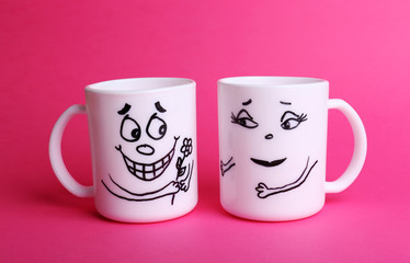 Emotional cups on pink background
