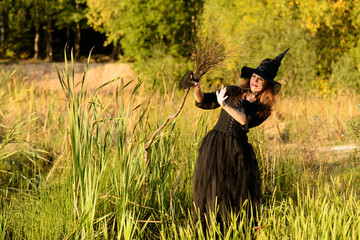 woman in witch's hat holding broom