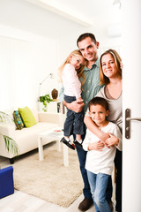 Fototapeta premium happy family with young kids welcoming a guests at home doorh