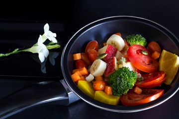 clean food, mix fruit and herb in pan on dark background