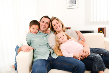 happy cheerful family playing together in the sofa at home
