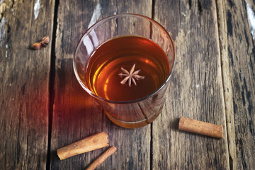 star anise in tea glass vibrant on wooden and cinnamon backgroun