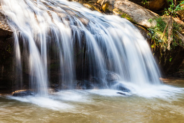 Fototapeta na wymiar Scenic waterfall flowing on stone at Mae Sa waterfall Doi Suthep