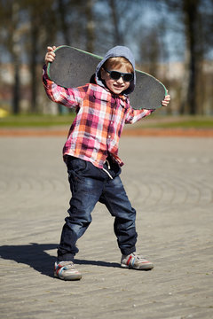 little boy with skateboard on the street