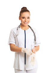 Happy female doctor putting on protective gloves