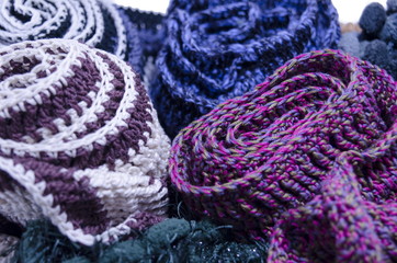 Obraz premium A bunch of handmade colorful woolen scarfs