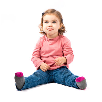 Cute Baby Girl Sticking Out Tongue Over White Background