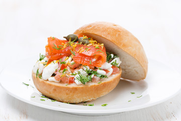sandwich with cheese, tomato and salmon on the white plate