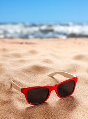 Fototapeta na wymiar Sunglasses on a sandy beach