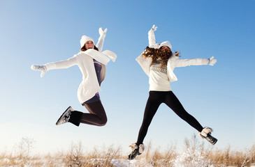 Two girlfriends have fun and enjoy fresh snow at beautiful winte