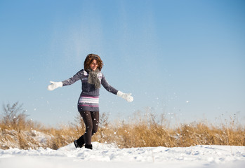 Happy young woman have fun and enjoy fresh snow at beautiful win
