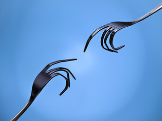 Two forks, pretending to be hands, trying to touch