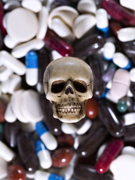 Skull in the pile of drugs. Sickness and danger of abuse