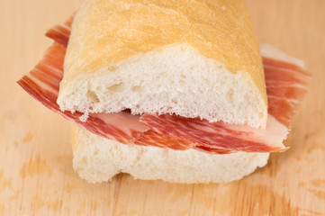 Front view of Serrano ham sandwich over wood