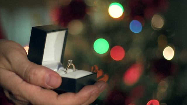 Engagement Ring Proposal Close Up. Christmas Tree Background 