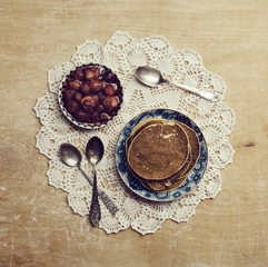 Pancakes with jam on the old patterned napkins on wooden table
