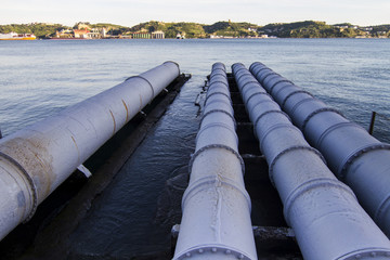View of old sewage pipes leading to a river.
