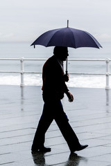 Hombre con paraguas paseando por la ciudad