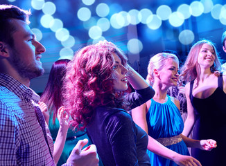 smiling friends dancing in club