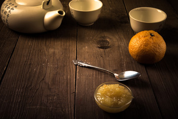 tangerine jam on background cups and teapot