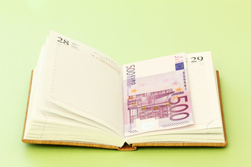 Blank page of note book and five hundred euro banknote
