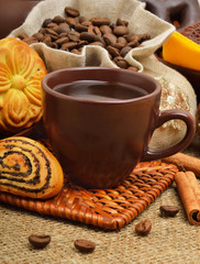 Cup of coffee with biscuits, coffee beans in bags and cinnamon s
