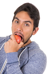 handsome young man biting red apple