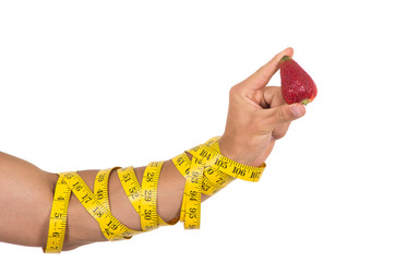 man's arm wrapped in measuring tape holding red strawberry