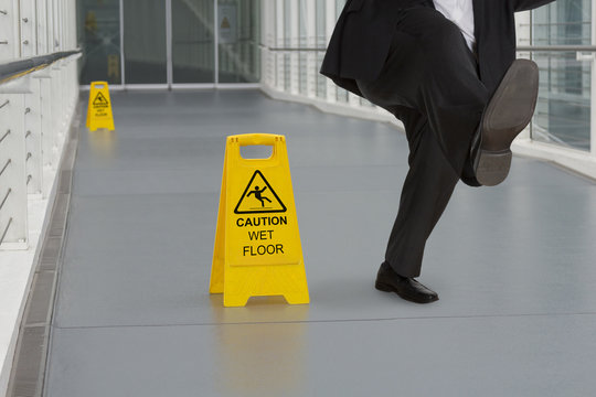 Man in suit slipping on wet floor
