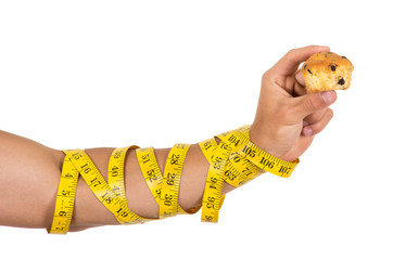 man's arm wrapped in measuring tape holding muffin