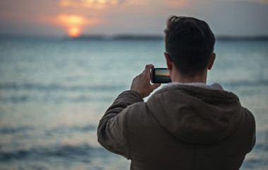 Man takes photographs sunset over the sea