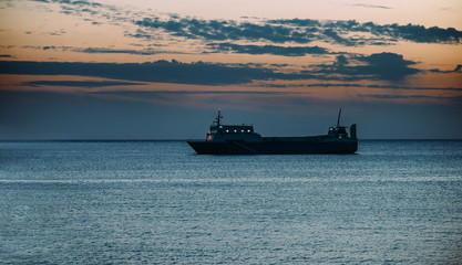 Ship in the blue sea at sunset