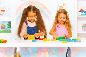 Two girls play with blocks in class