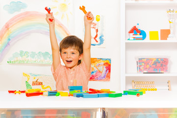 Fototapeta premium Cute happy boy with wrenches in the kindergaten